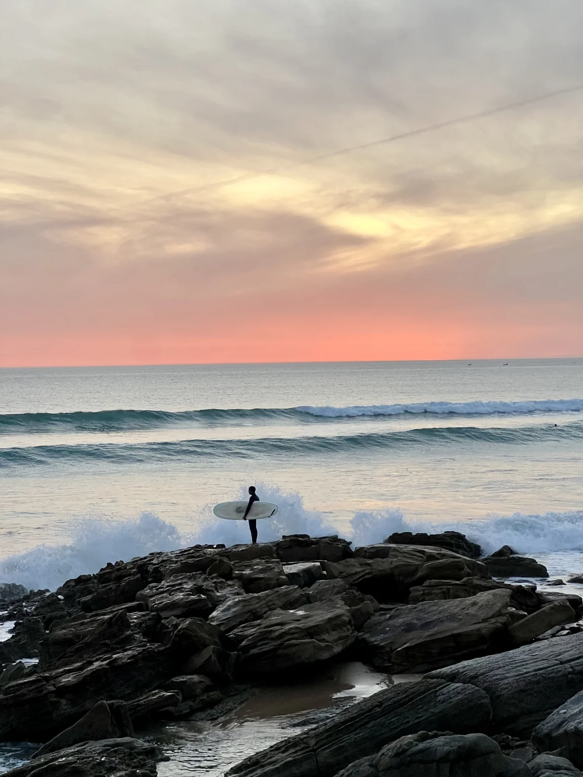 Young surfer in wetsuit with surfboard at the ocean for Tayyurt Surf camp Morocco- Best Surf Spots